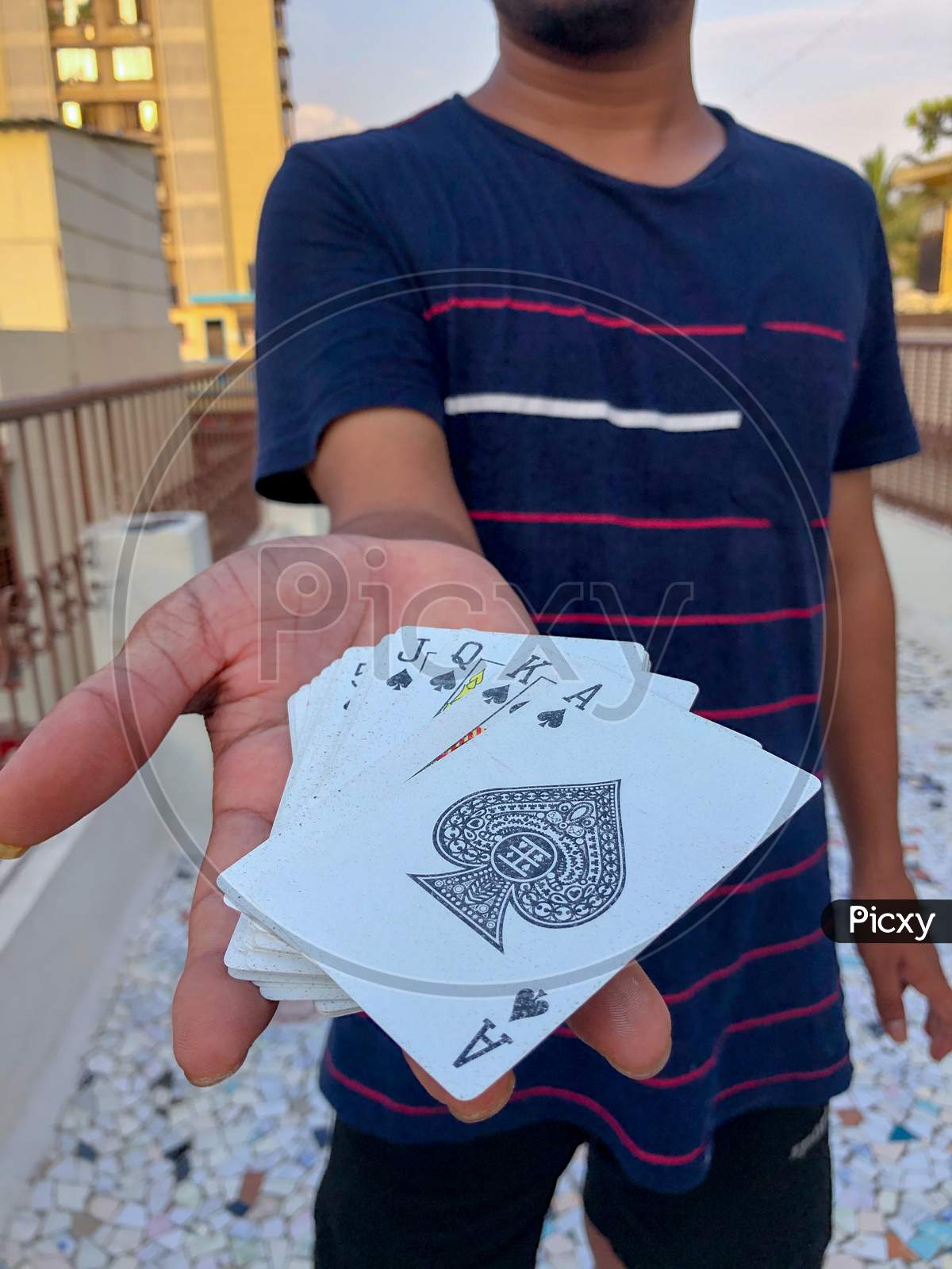 young Asian guy holding deck of cards