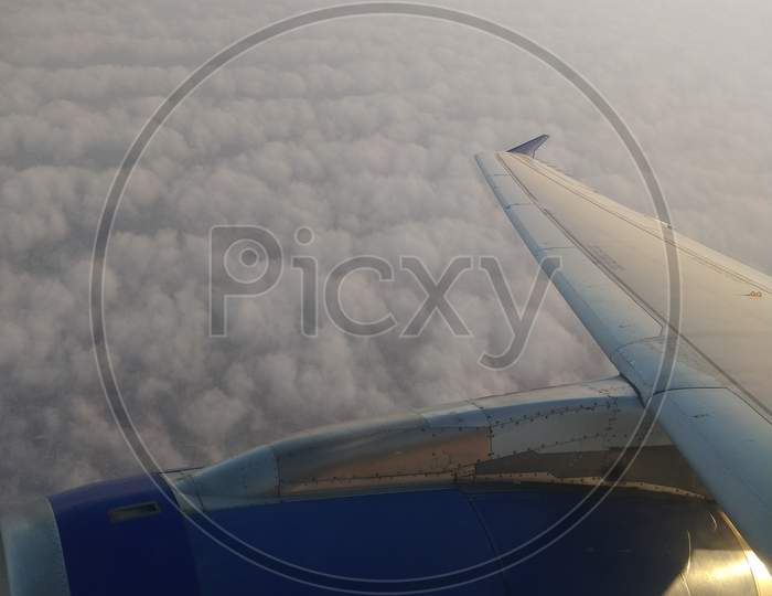 Indigo plane in the skies with clouds