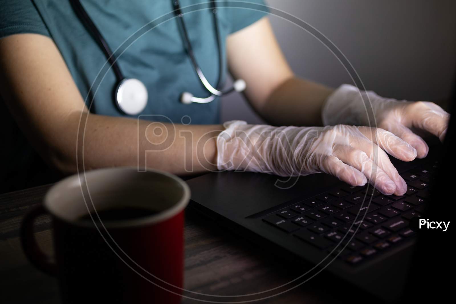 Doctor or nurse's hands on keyboard in the dark. Long hours or overtime work of medical worker concept.Doctor or nurse's hands on keyboard in the dark. Long hours or overtime work of medical worker concept.
