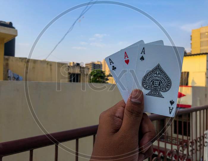 poker playing cards in hand with corporate background and blue sky