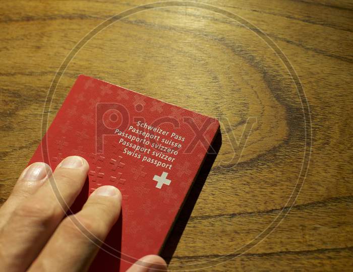 Single Swiss Passport On A Wooden Table