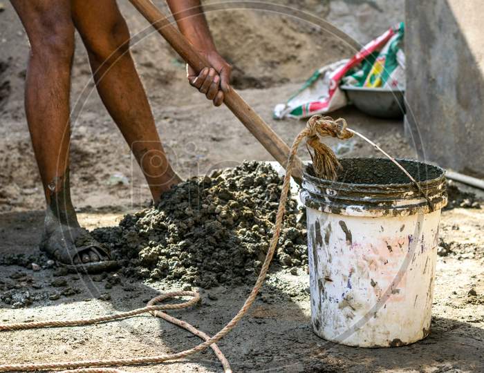 A man prepares concrete using cement and aggregates to construct septic tank