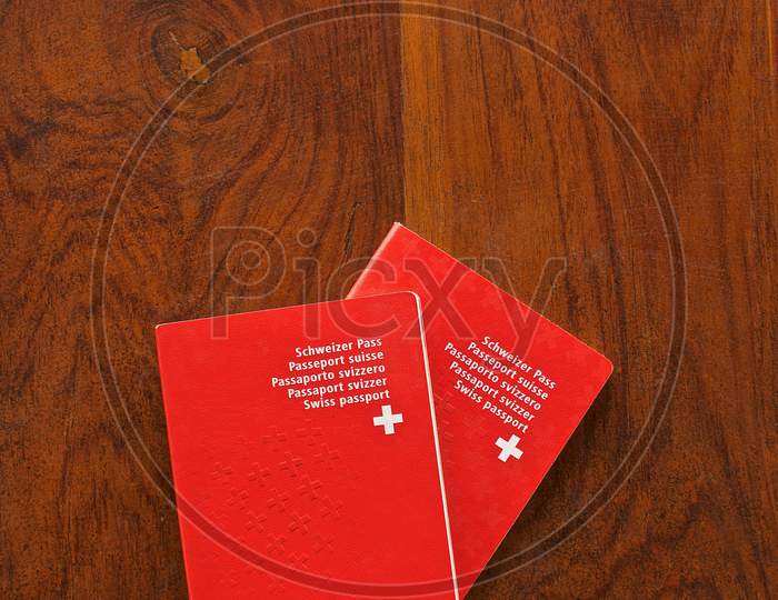 Two Swiss Passports On A Wooden Table
