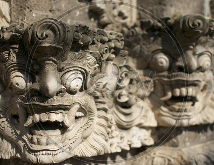 Beautiful Balinese Masks Engraved In A Stone Wall