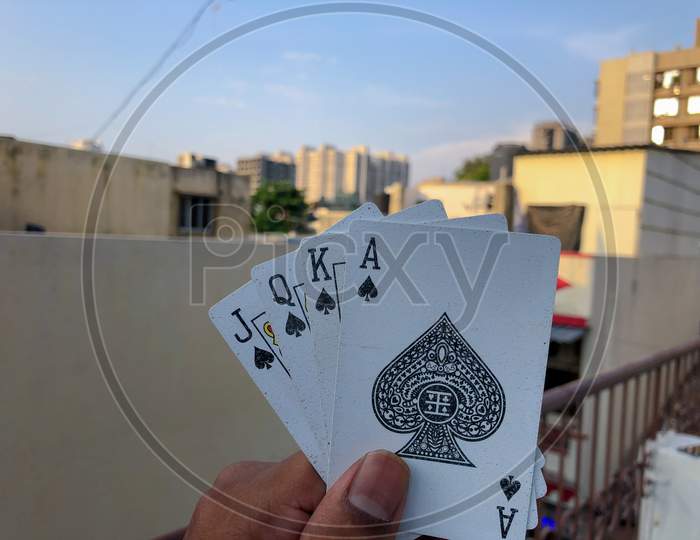 young Asian holding  four cards in hand with corporate background and blue sky