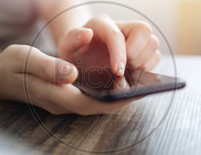 Vintage close up of woman hands holding smartphone, touching a mobile phone screen. Online communication concept