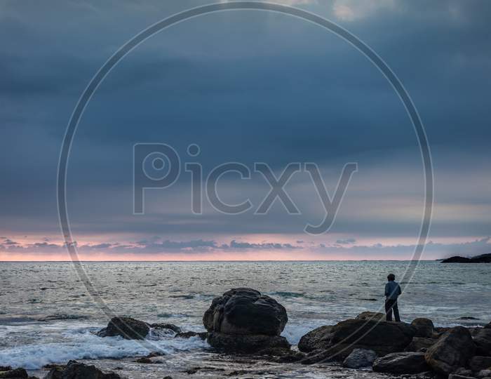 Man Watching Sea Horizon From Standing On Rock