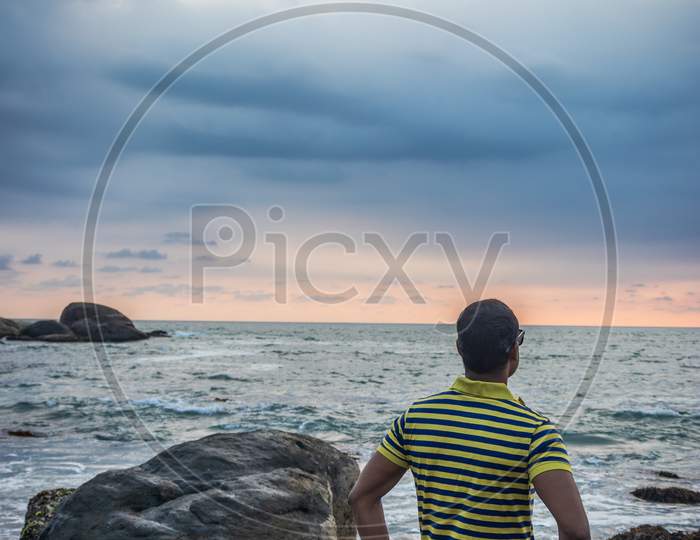 Man Isolated Watching The Sea Horizon With Dramatic Sky