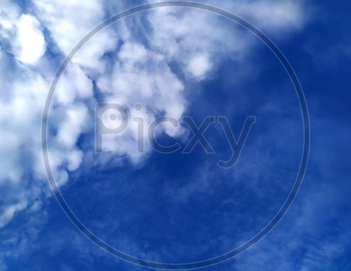 white rainy clouds flying in the blue sky