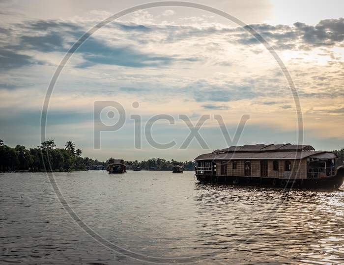 Houseboats In Backwater With White Clouds