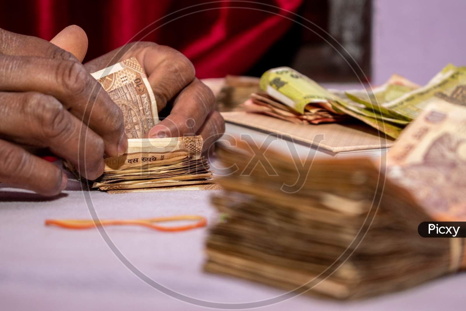 A man counting Indian currency notes put on table
