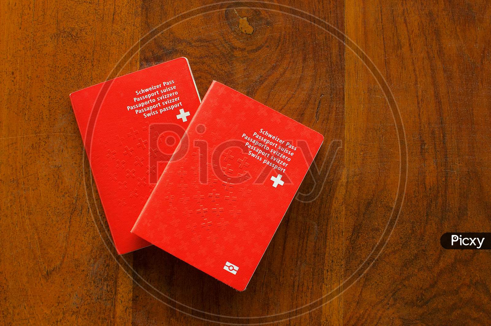 Two Swiss Passports On A Wooden Table
