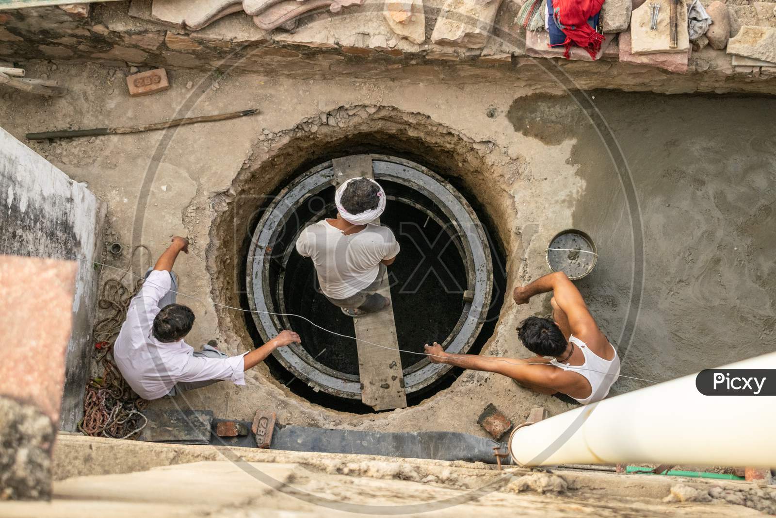 Men working during construction of septic tank outside a house
