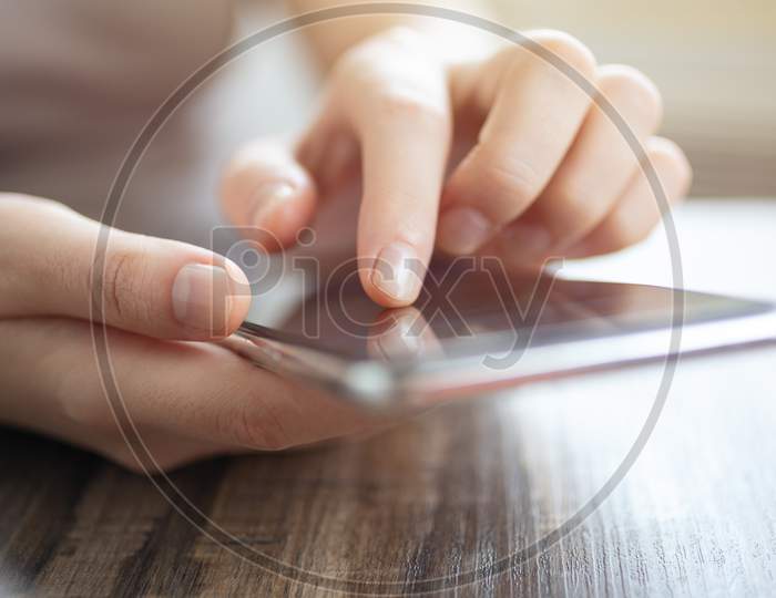 Vintage close up of woman hands holding smartphone, touching a mobile phone screen. Online communication concept