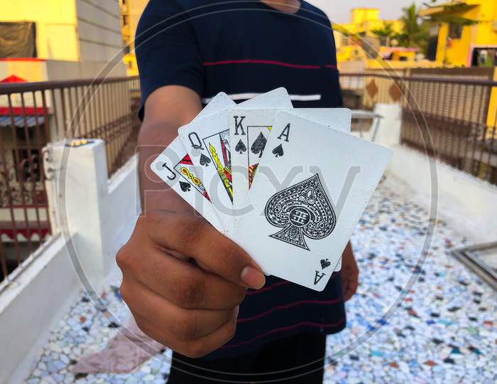 guy holding four top playing cards