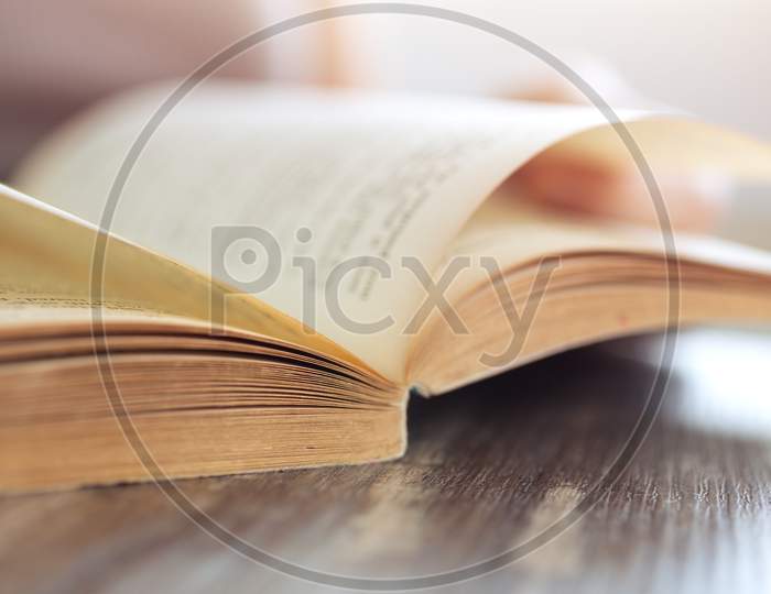 Vintage close up of an old open book with yellow pages. Avid reader, bookworm concept