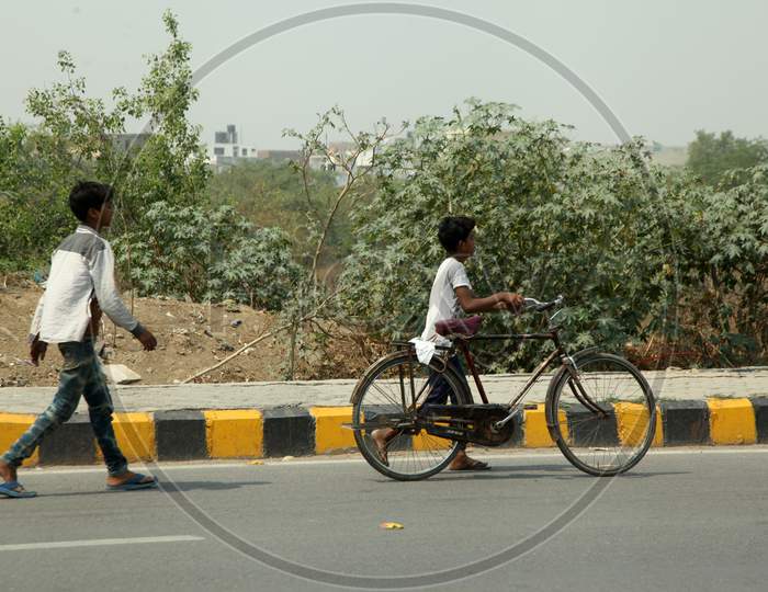 A Kids walking with Bicycle