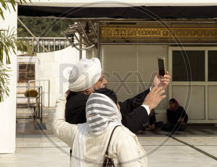 A Couple taking selfie using Smartphone in Golden Temple
