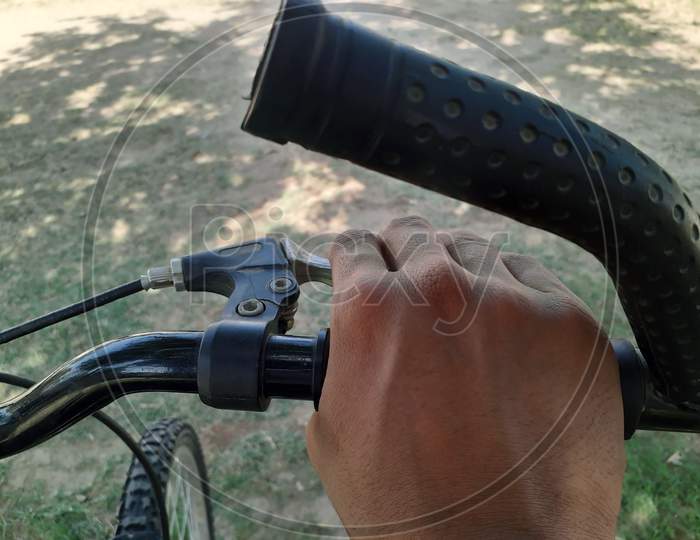 An Asian Person Is Holding Bicycle Steering And Its Brakes
