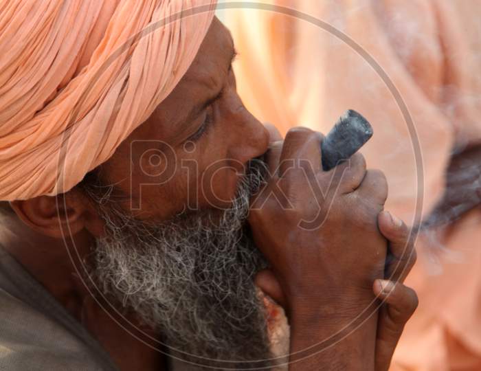 Portrait of an Old Indian Hindu Sadhu or Baba Smoking Chillam