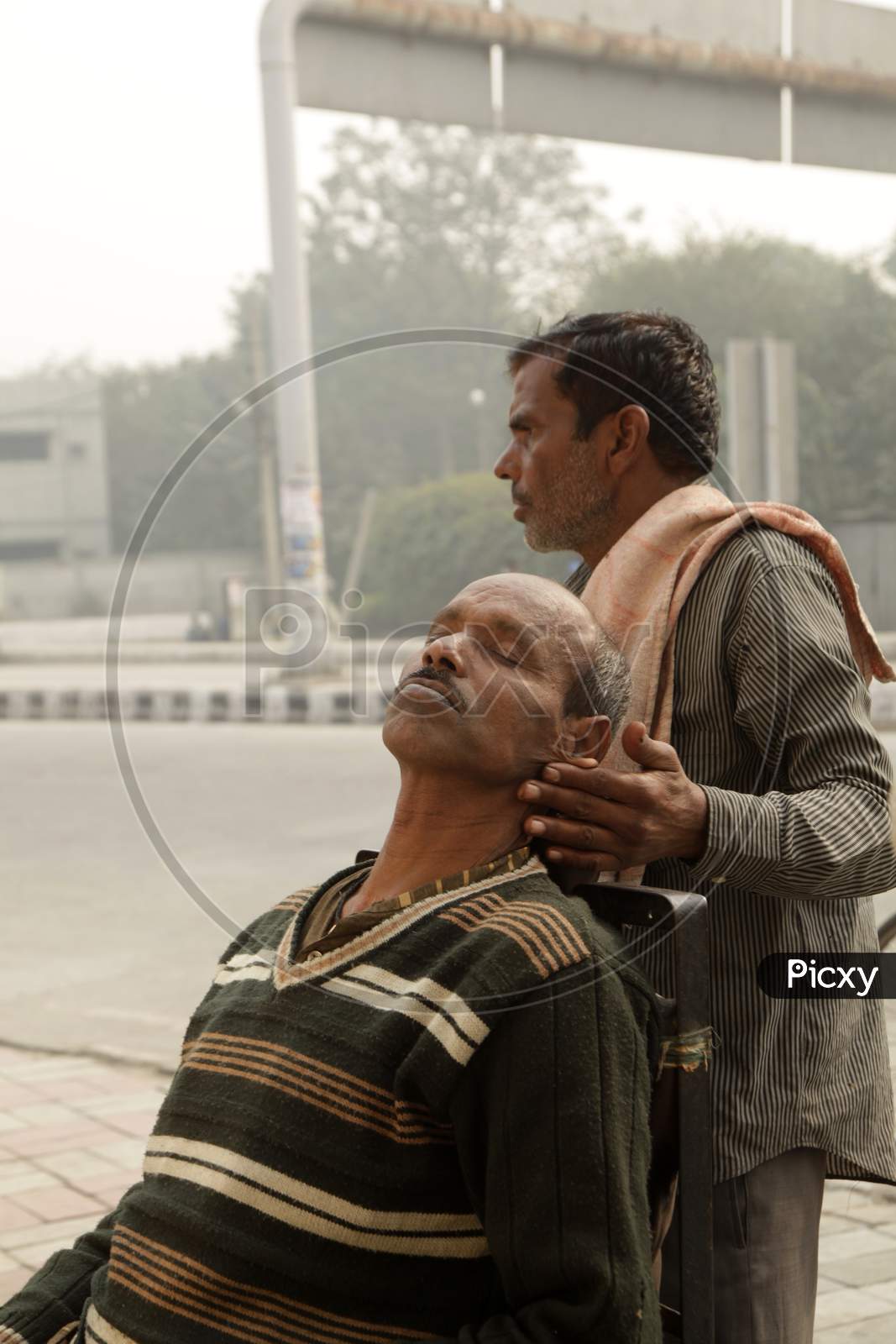 An Indian street barber giving his client a head massage