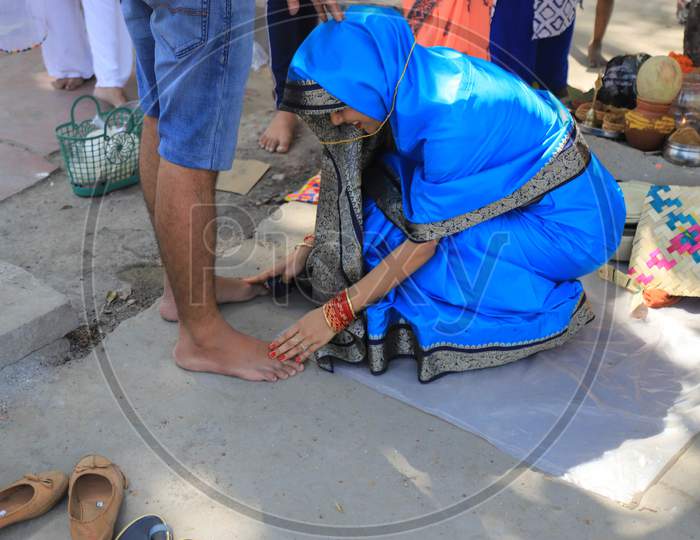 Married Hindu Woman Touching Feet Of Her Husband After Tying Cotton Threads Around A Banyan Tree On The Occasion Of "Vat Savitri Festival", For Their Husbands' Health And Longevity, In Prayagraj, May 22, 2020.