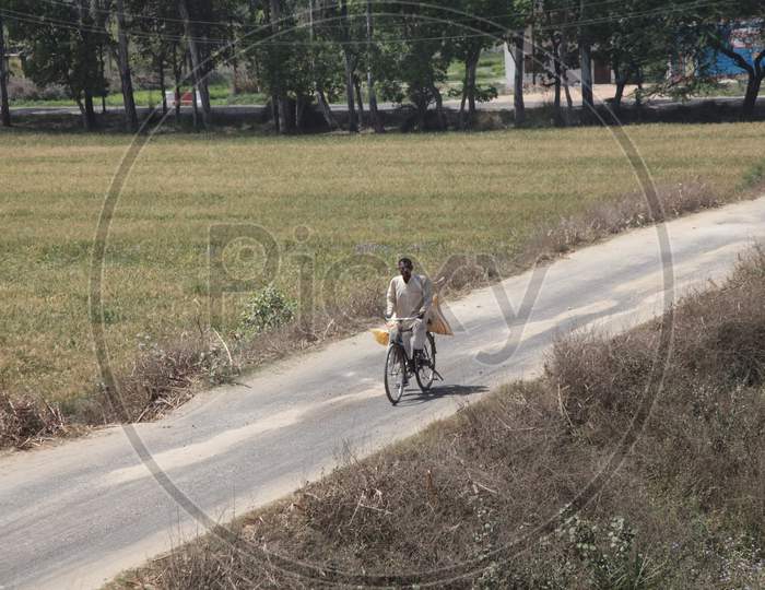 A Person riding a bicycle on a single lane road