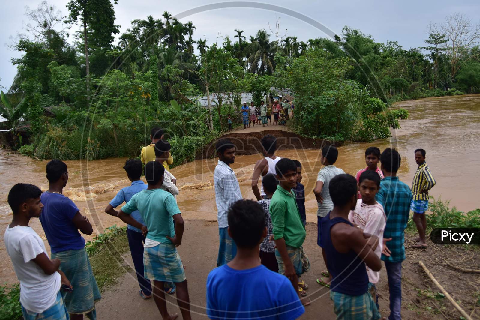Villagers Watch A Washed Away Road After Flooding By Borpani River  Due To Incessant Rainfall For The Past Two Days, At  Madhab Para Near Kampur In Nagaon District Of Assam,India May 22,2020