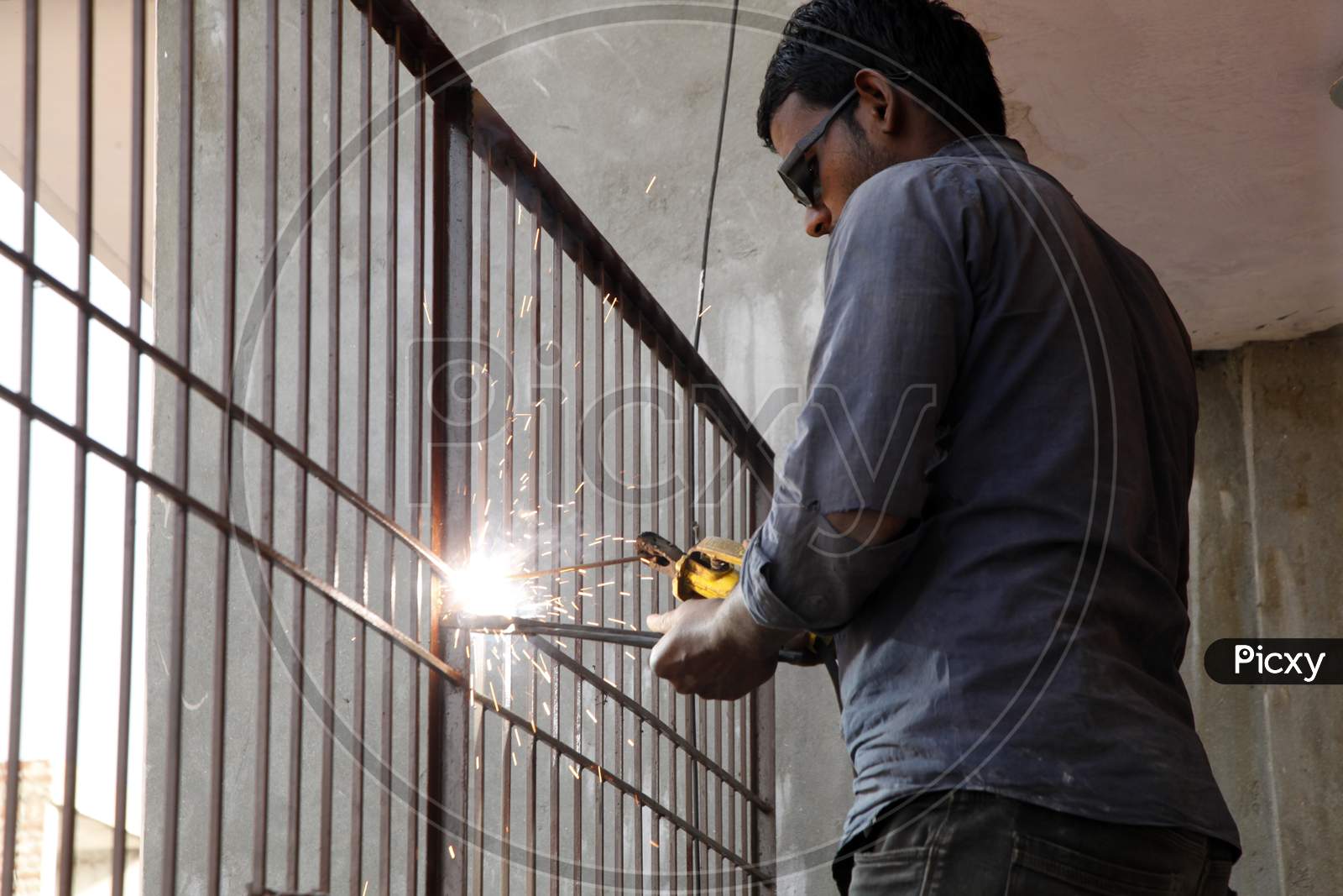 A Young Welder doing welding with Welding Goggles