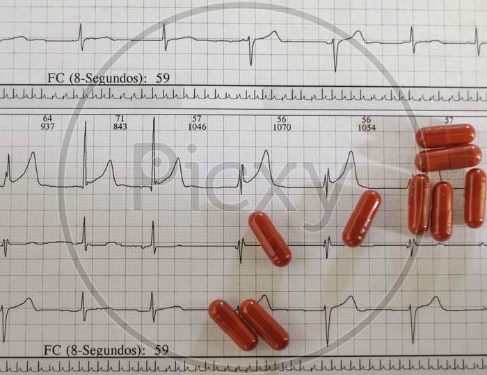 Red Capsules On An Electrocardiogram. Medicines For The Heart.