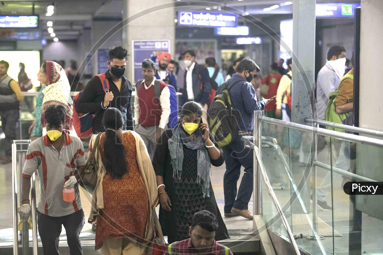 A People Wearing A Facemask As A Preventive Measure Against The Covid-19 Novel Coronavirus Walks Out Of A Metro Station In New Delhi On March 13, 2020.
