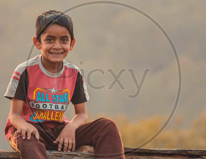 Almora, Uttrakhand, India- May 22 2020: A Travel Portrait Of A Young Kid Smiling Looking Into The Camera