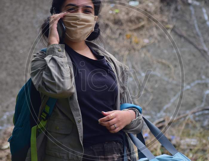 Young woman with  backpack  wearing protection face mask against coronavirus 2019-nCoV