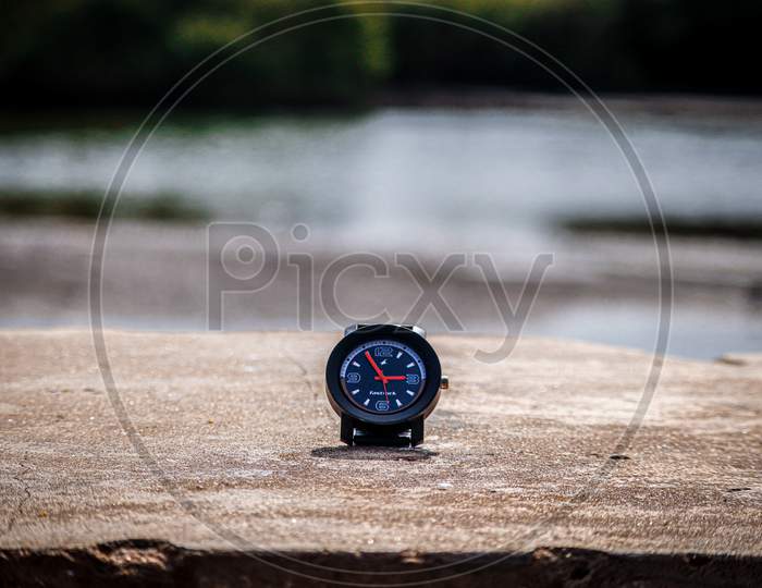 Close-up designer watch on beach, importance of the time