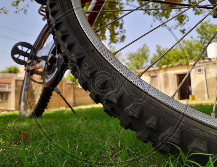 Closeup Of Bicycle Tyre Standing In Grass At Home Lawn Or Garden