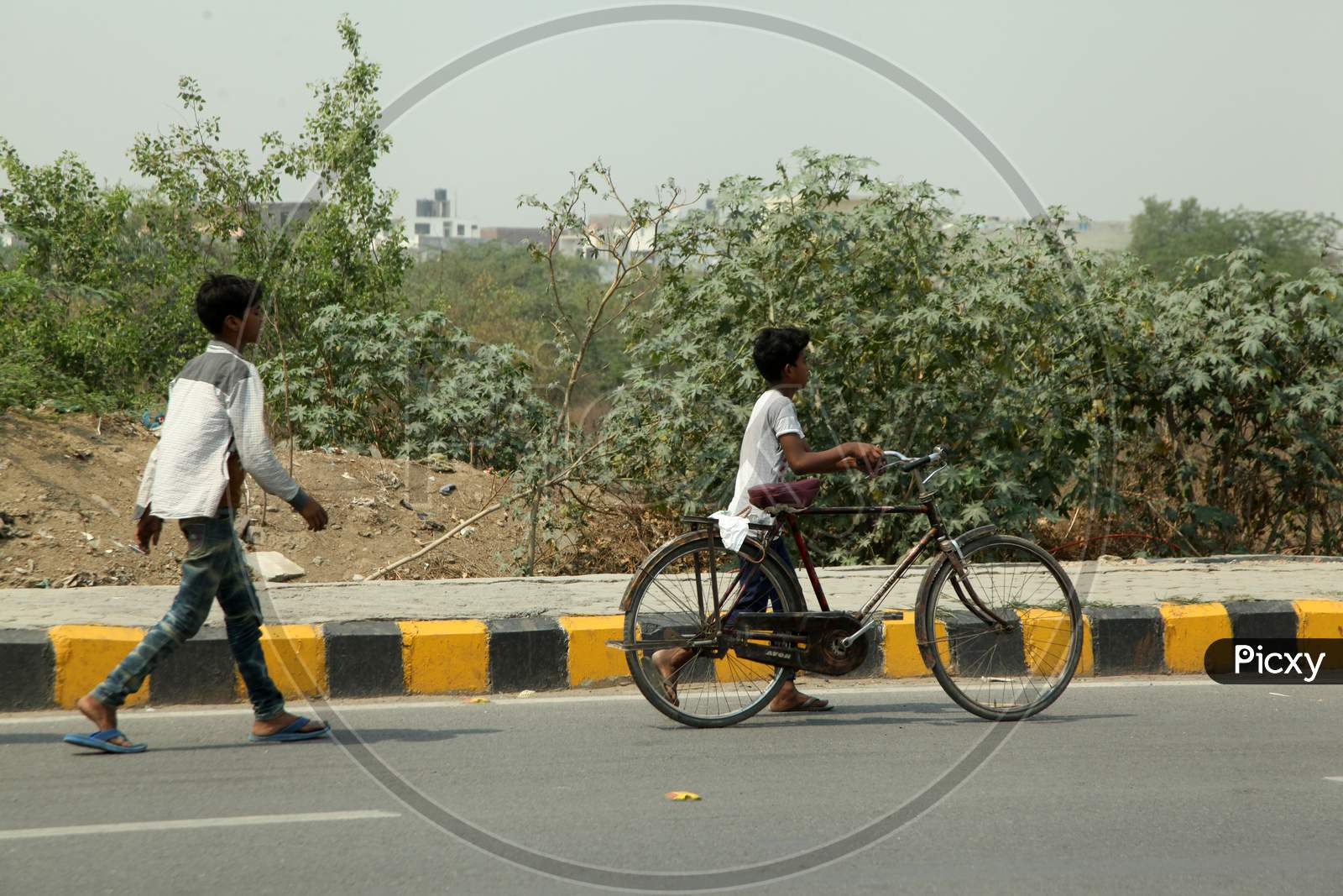 A Kids walking with Bicycle