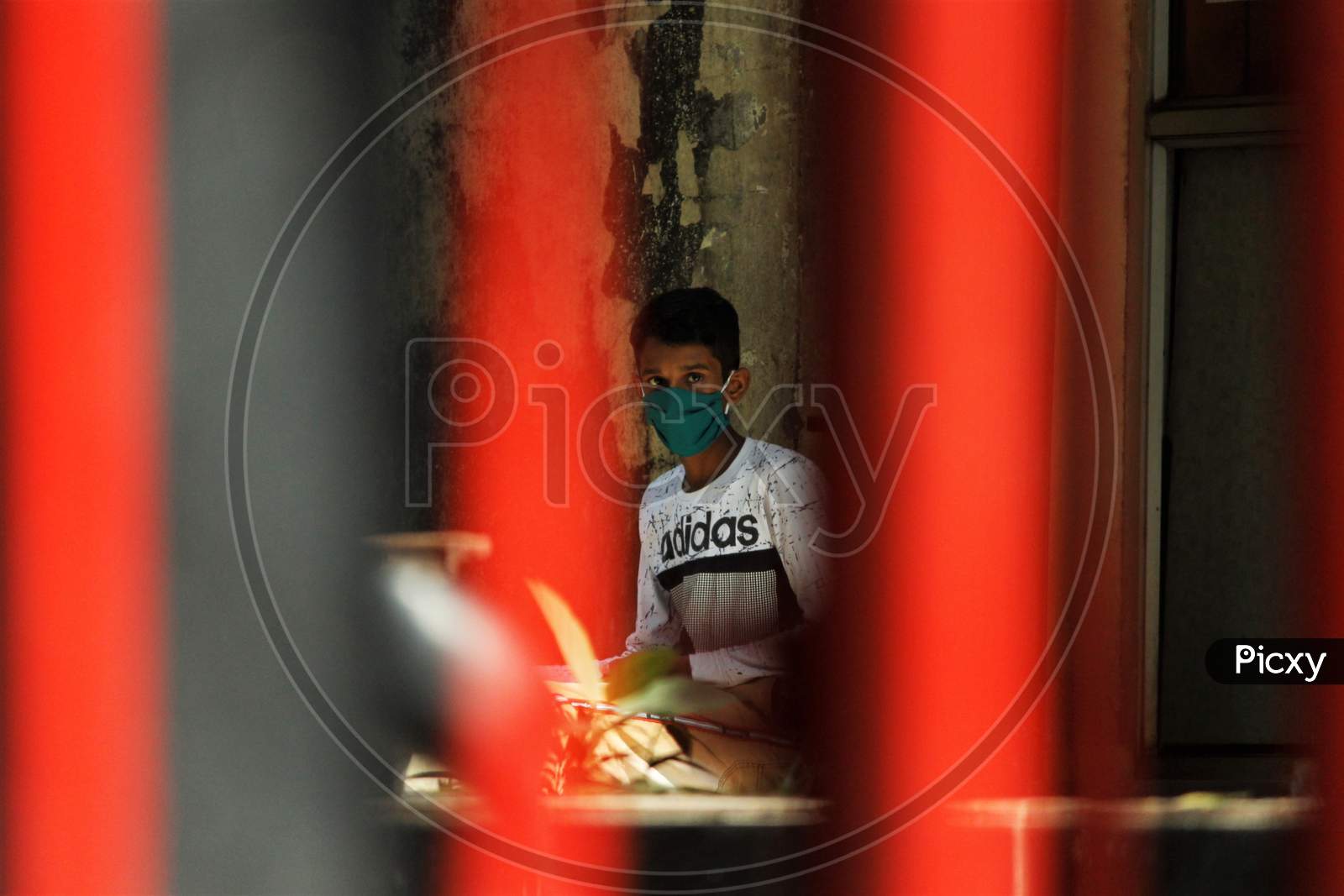 A boy wearing a protective mask is seen inside the premises of a hospital where a special ward has been set up for the coronavirus patients in Mumbai, India on March 5, 2020.
