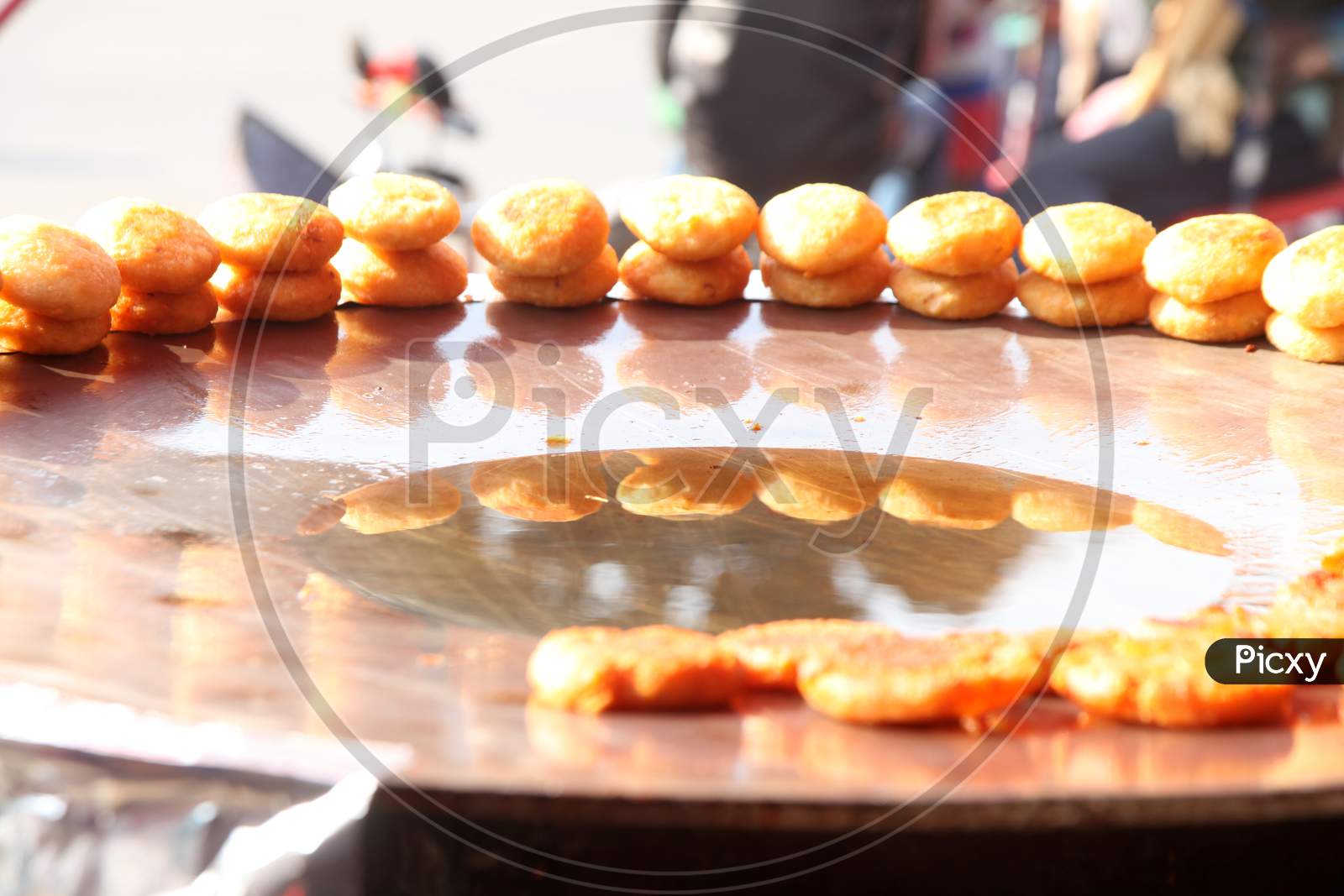 Selective focus on Samosa's with people in the background