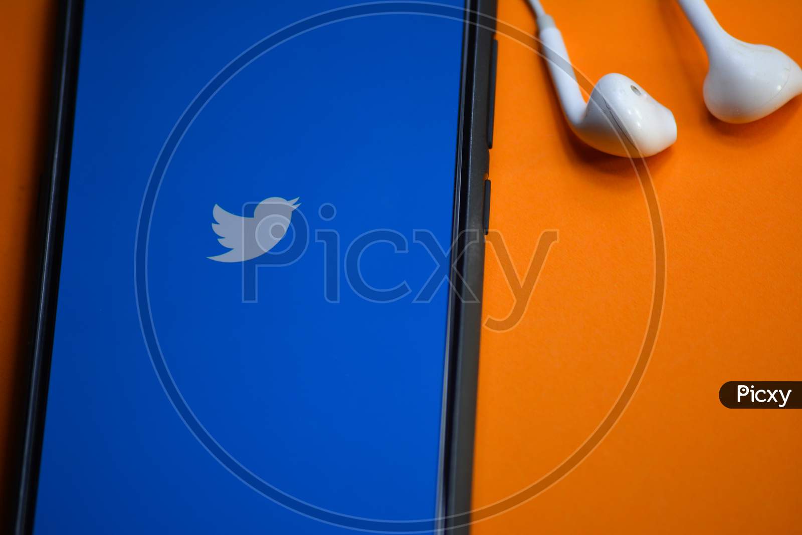 TIKAMGARH, MADHYA PRADESH, INDIA - DECEMBER 17, 2019: Twitter logo on smartphone screen and earphones. Twitter is a social media online service for microblogging and networking communication.