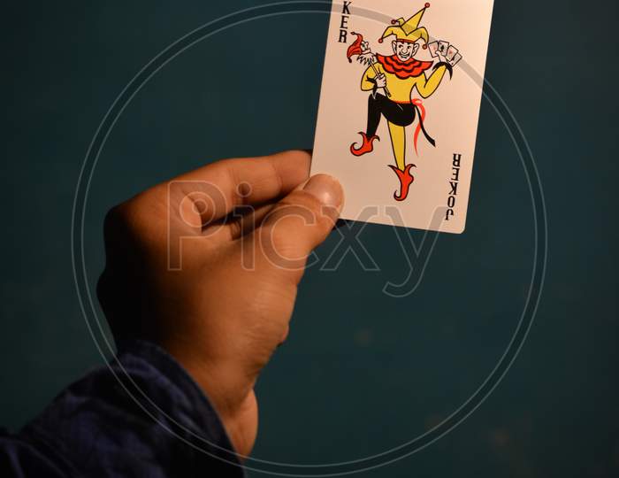TIKAMGARH, MADHYA PRADESH, INDIA - DECEMBER 15, 2019: Hand holding joker playing card.