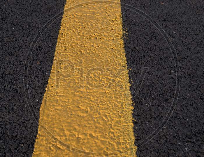 Yellow Line Across Dark Asphalt