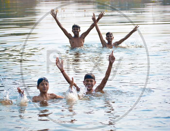 TIKAMGARH, MADHYA PRADESH, INDIA - NOVEMBER 13, 2019: Indian village boys swimming in the fresh river water.