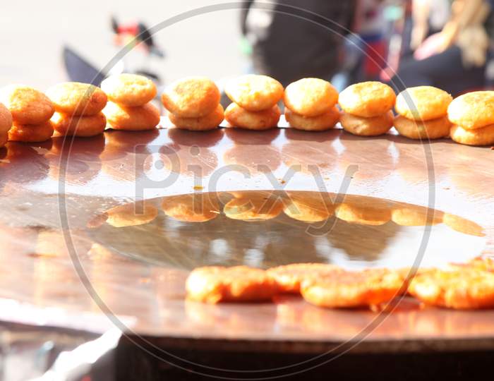 Selective focus on Samosa's with people in the background