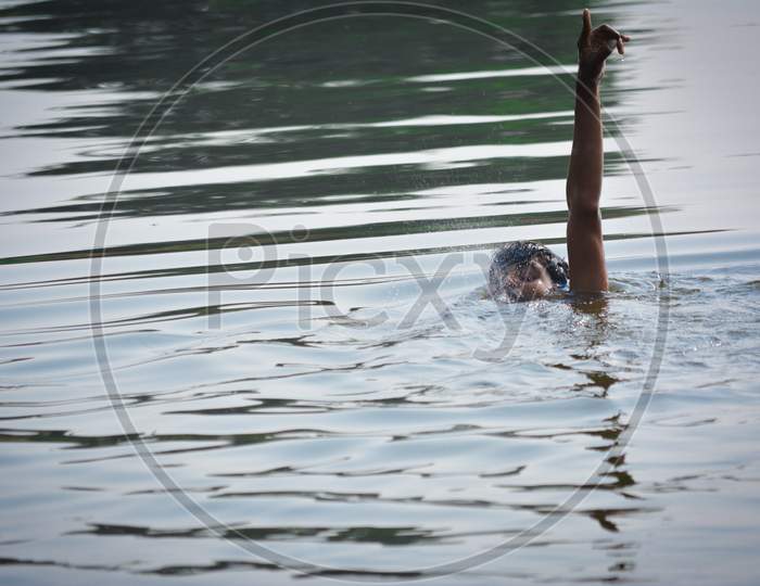 TIKAMGARH, MADHYA PRADESH, INDIA - NOVEMBER 13, 2019: Unidentified Indian village boy swimming in the fresh river water.