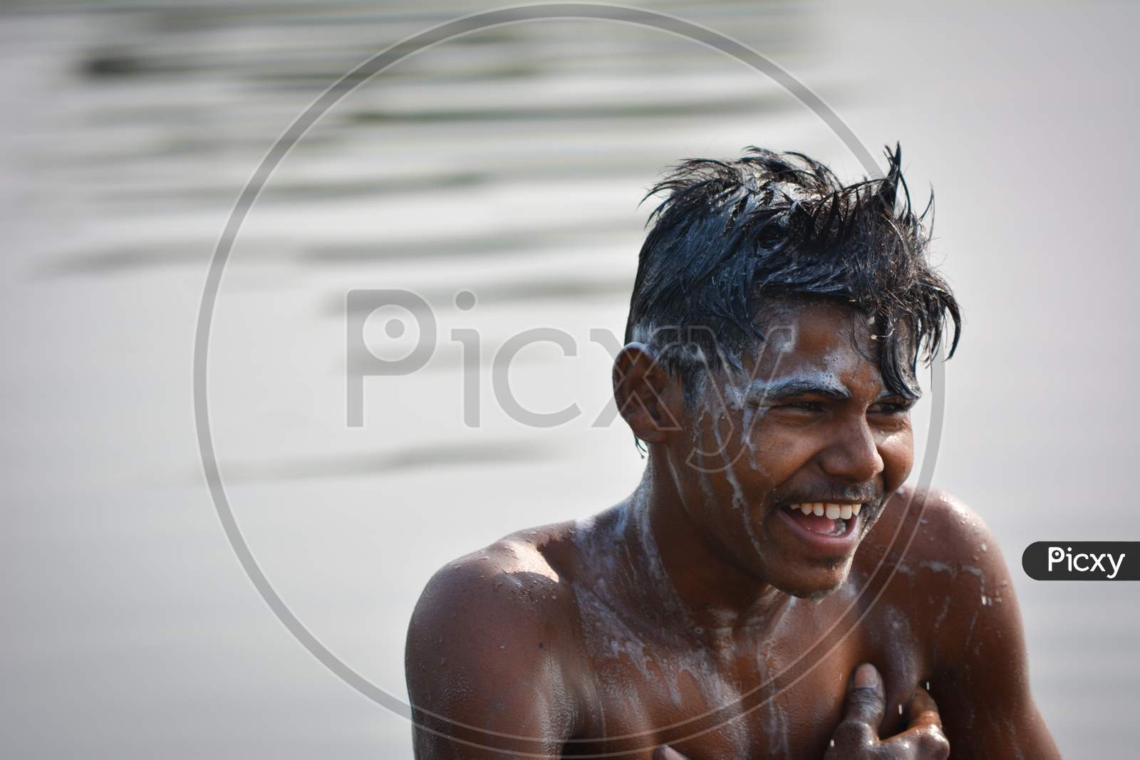 TIKAMGARH, MADHYA PRADESH, INDIA - NOVEMBER 13, 2019: Indian village boy bathing in the river on morning, Washing body and hair with shampoo.