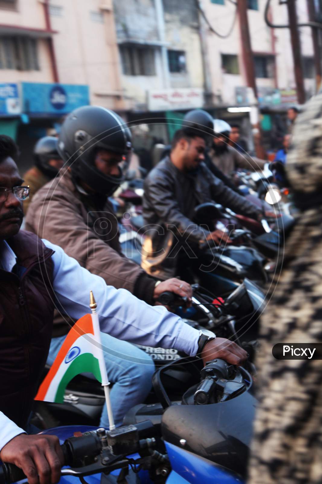 A man riding a bike with Indian Flag on the Bike