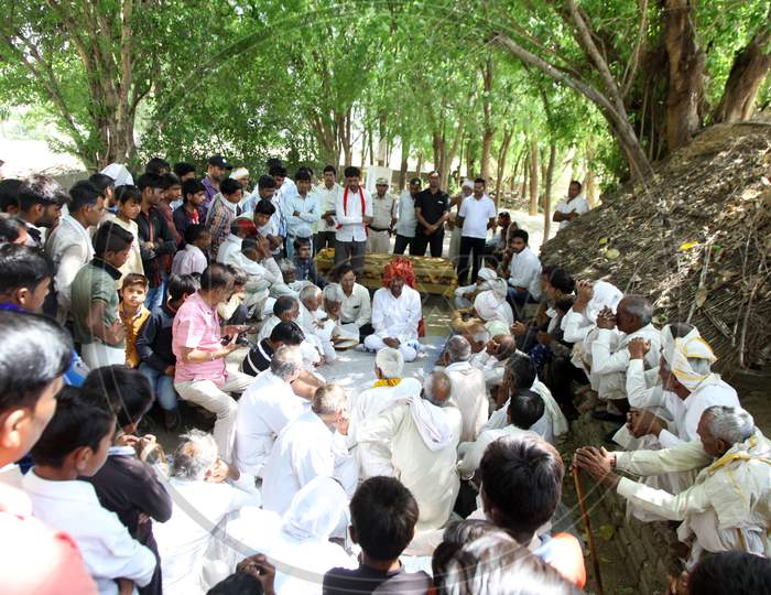 Group of people sitting under a tree and Discussing with each other