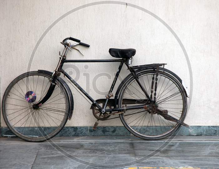 A Bicycle parked alongside a Wall