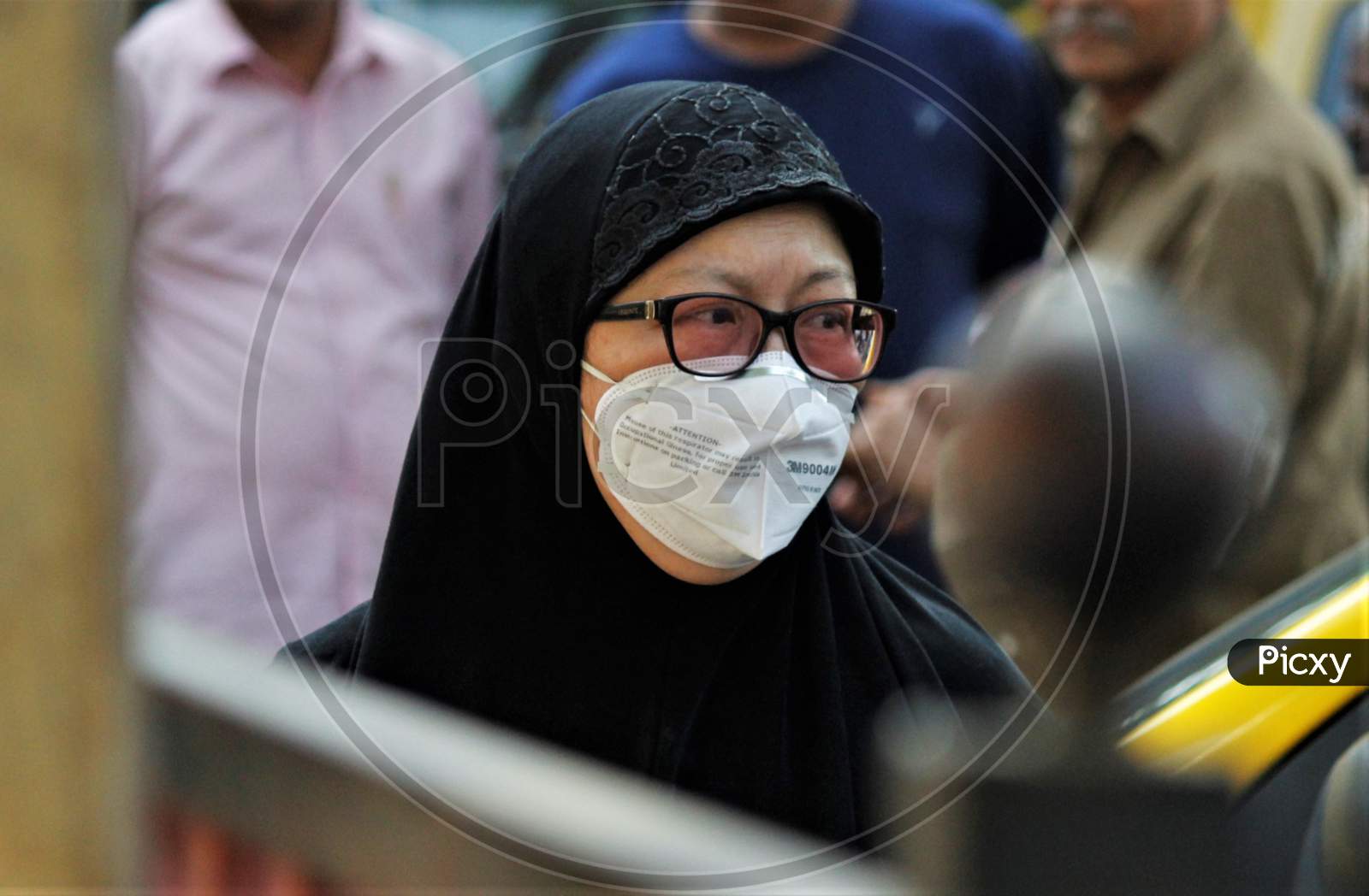 A woman wearing a protective mask is seen outside the premises of a hospital where a special ward has been set up for the coronavirus patients in Mumbai, India on March 5, 2020.