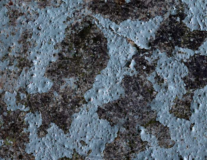 Detailed and colorful close up at cracked and peeling paint on concrete wall textures in high resolution